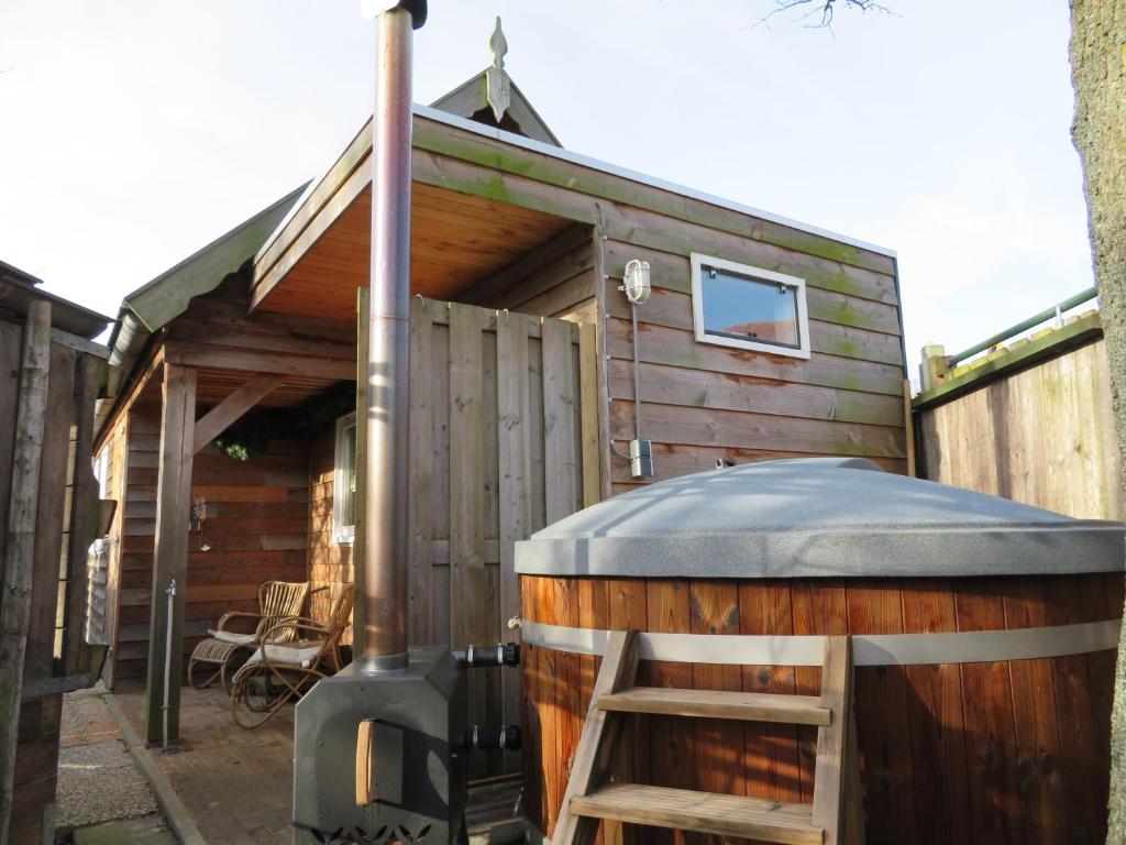 een grote houten hut met een grote houtkachel bij Casa Koudekerke in Koudekerke