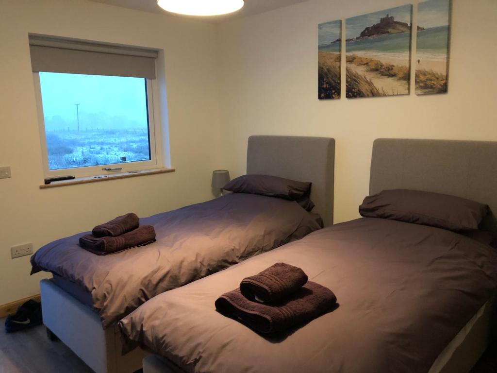 Duas camas num quarto com uma janela em Edindoune em Strathcarron