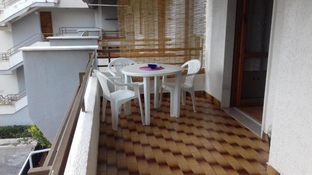 a white table and chairs on a balcony at Appartamento Pitagora in Scalea