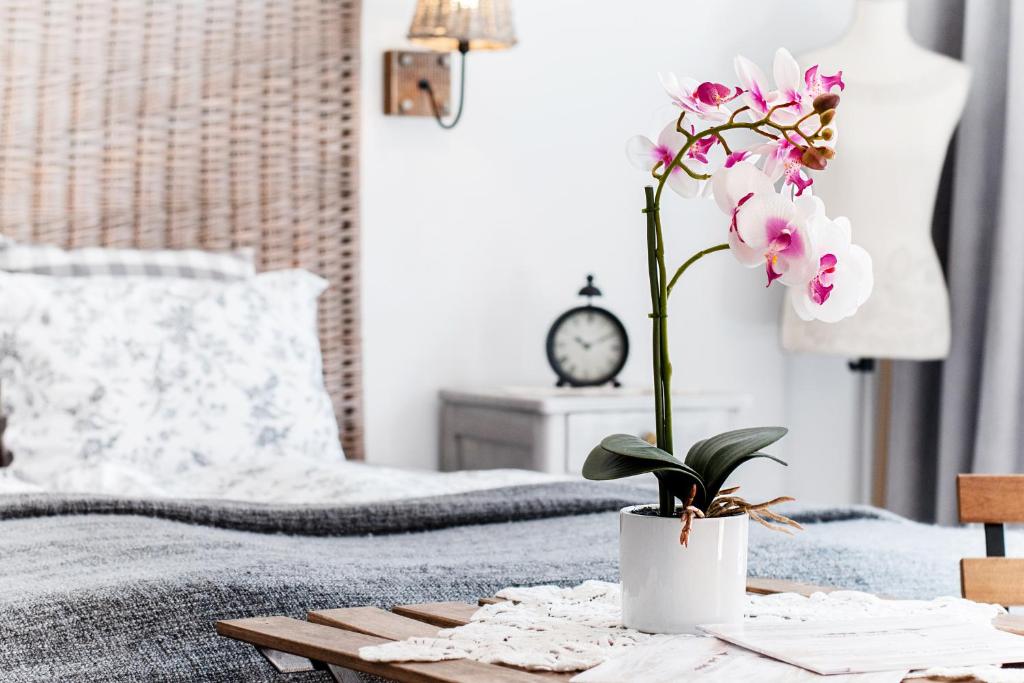 un jarrón de flores sobre una mesa en un dormitorio en Madárlátta Vendégház, en Fertőrákos