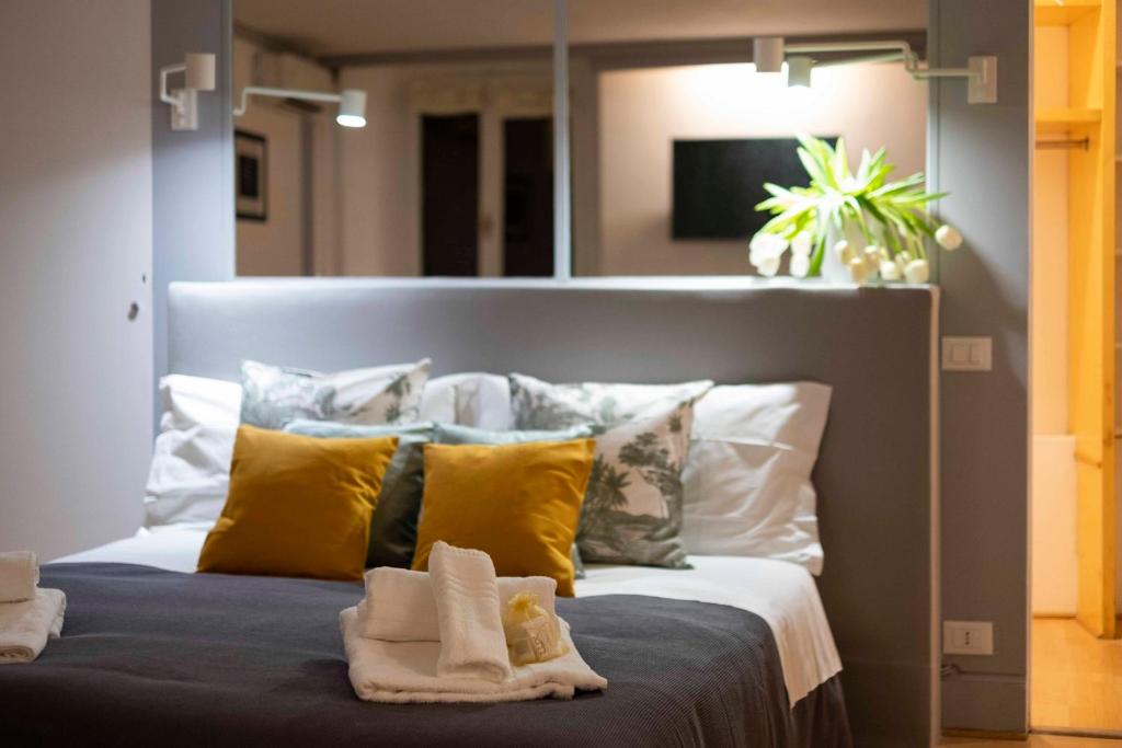una camera da letto con un grande letto con cuscini gialli di Casa Paola Guesthouse a Roma