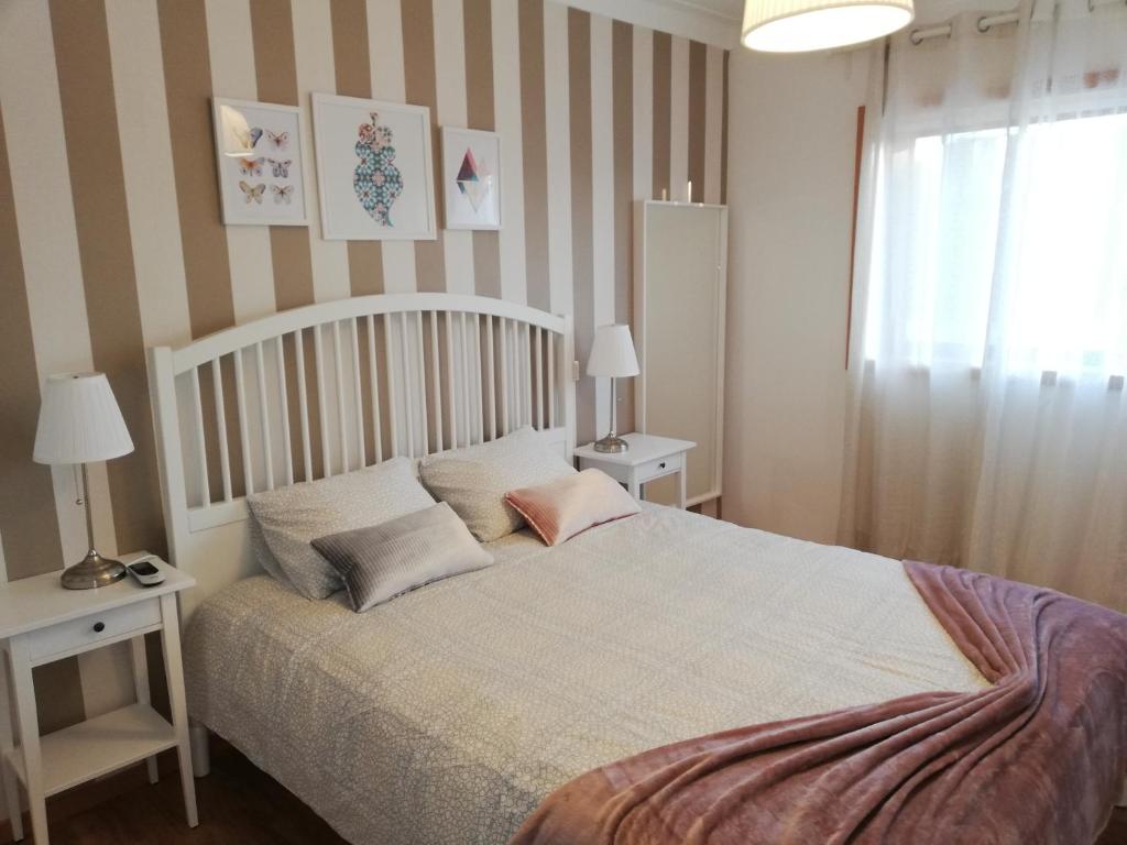 a bedroom with a bed with two tables and a window at Apartamento da Giesta in Rio Tinto