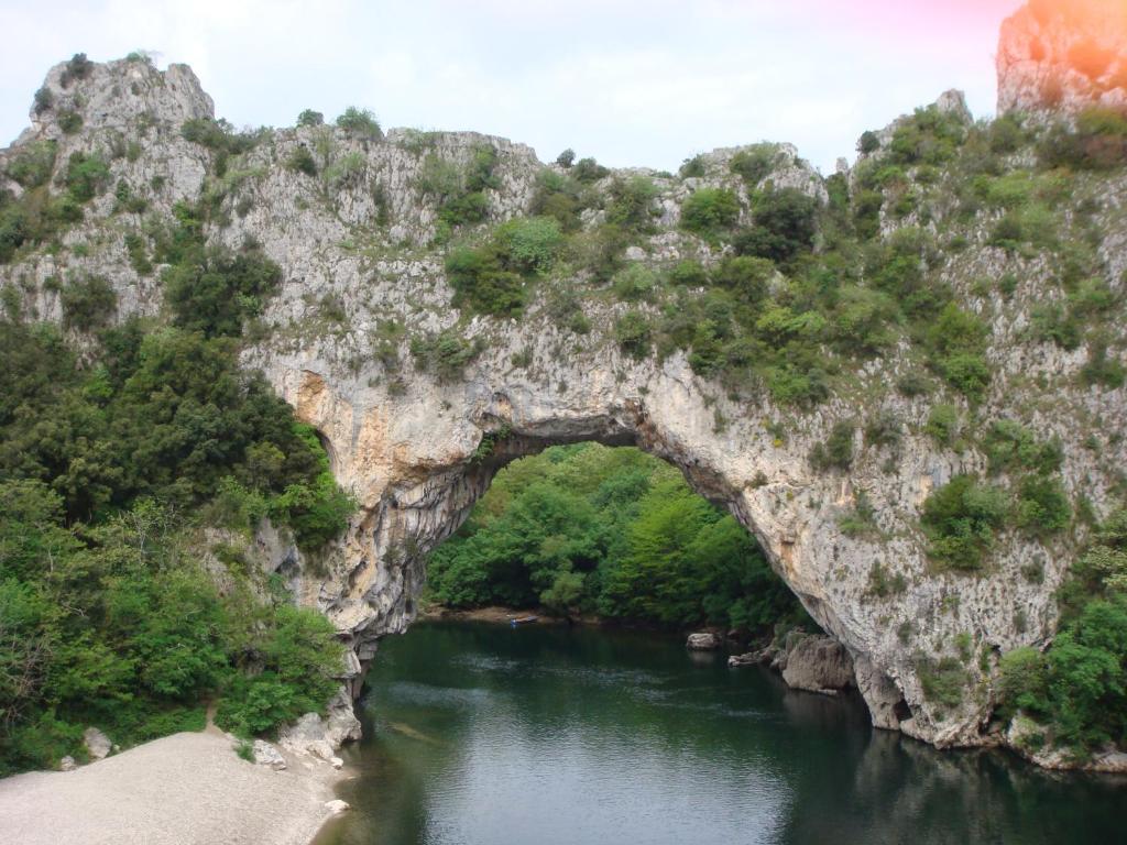 einem Torbogen in einer Felsformation über einem Fluss in der Unterkunft Clos l'Oustal in Labastide-de-Virac