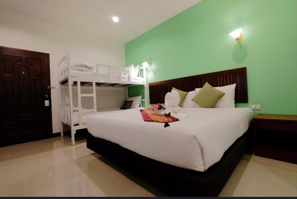 a bedroom with a large white bed and a bunk bed at BS Airport at Phuket in Nai Yang Beach