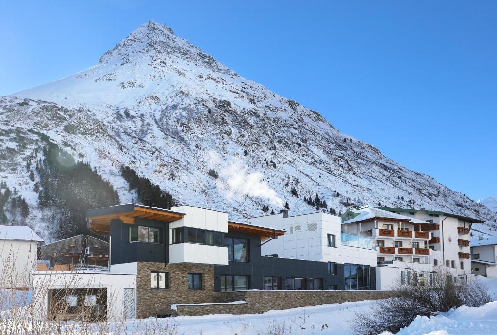 een gebouw met een berg op de achtergrond bij Alpenresidenz Ballunspitze - Kinderhotel in Galtür