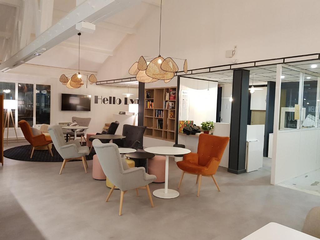 a living room with chairs and tables and a table at KYRIAD LYON EST – Saint Quentin Fallavier in Saint-Quentin-Fallavier