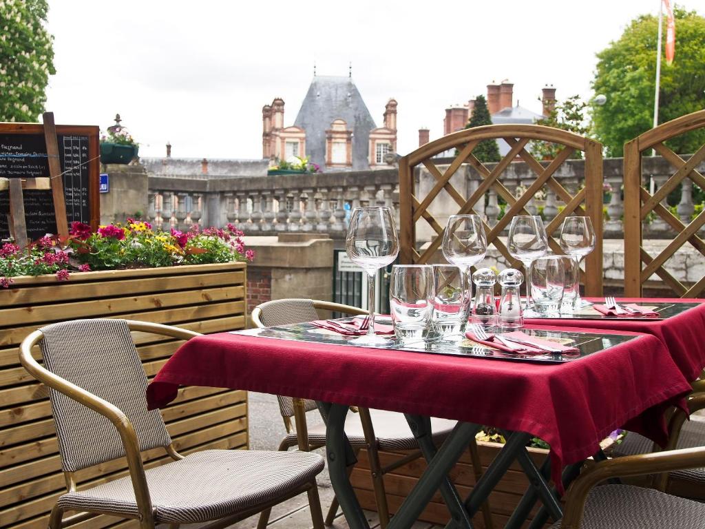 uma mesa com copos de vinho sentados num pátio em Le Richelieu Bacchus em Fontainebleau