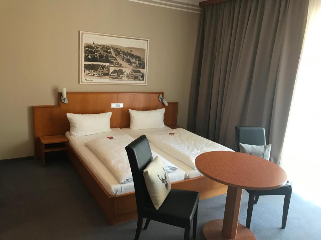 A bed or beds in a room at Neumaiers Hirsch -Gasthof und Landhotel