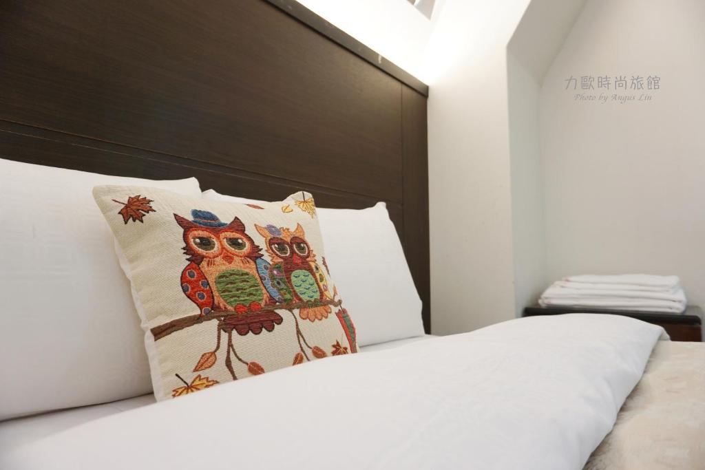 a bed with a pillow with an owl on it at Lio Hotel - Taipei Main Station in Taipei