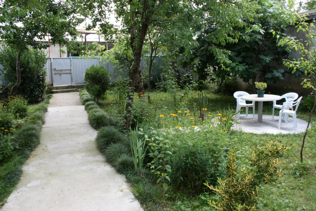 a small garden with a table and chairs in it at Guesthouse Gegi in Kutaisi