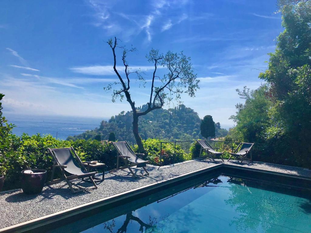 a swimming pool with chairs and a view of the ocean at Villa Franca Portofino by KlabHouse in Portofino