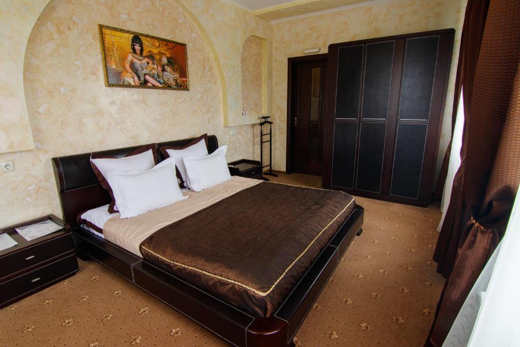 a bedroom with a large bed with white pillows at Шахерезада in Vinnytsya