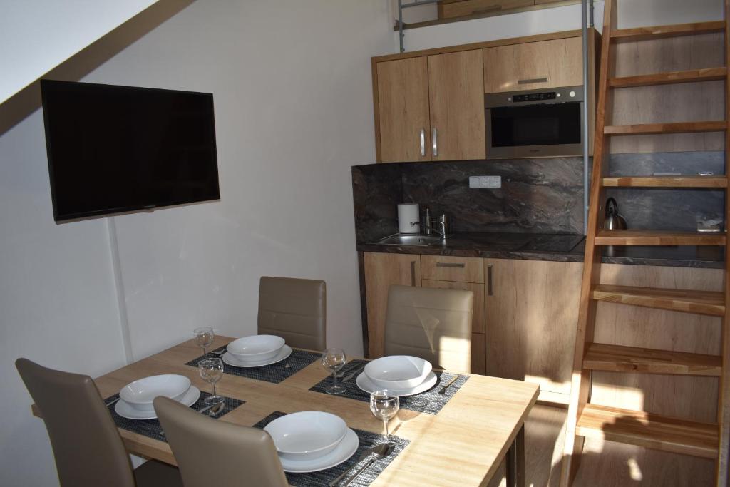 a dining room with a table with chairs and a television at Apartma FARA in Loučná nad Desnou