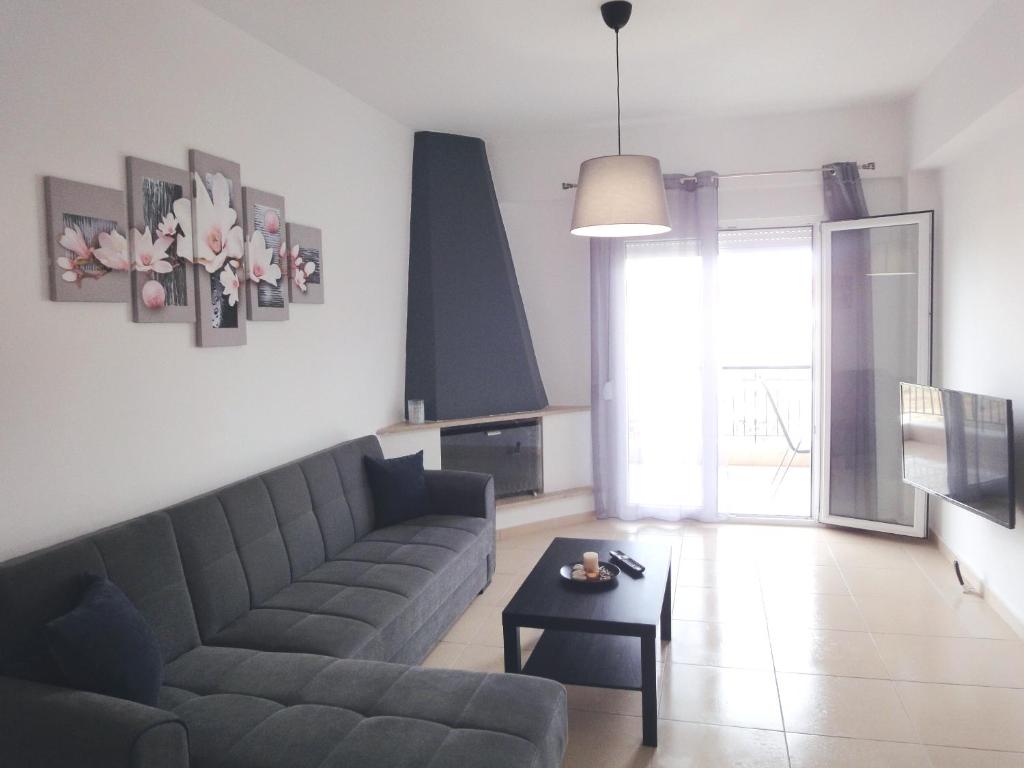 un soggiorno con divano e tavolo di Polychrono Nikos Apartment a Polykhrono