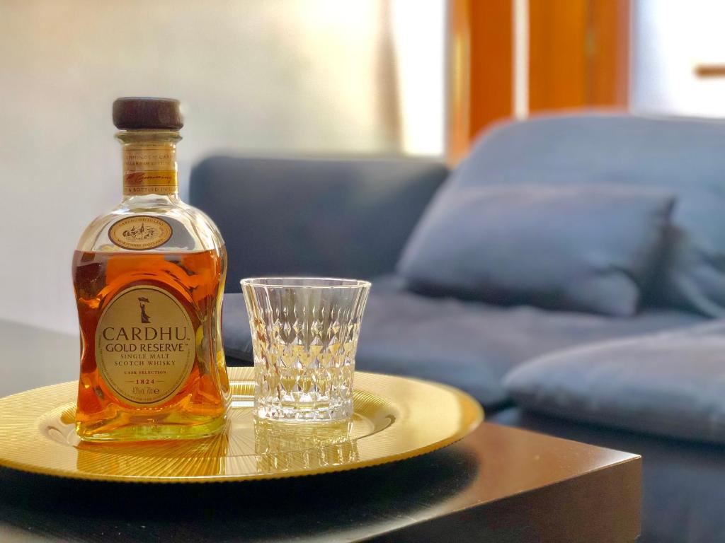 a bottle of whisky and a glass on a table at Ático Centro Málaga in Málaga