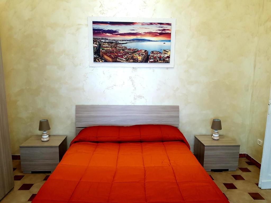 a bedroom with a red bed with two night stands at Duomo Central Loft in Naples