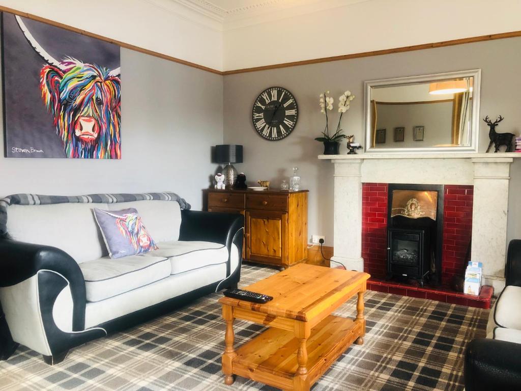 a living room with a couch and a fireplace at The Gables in Crail