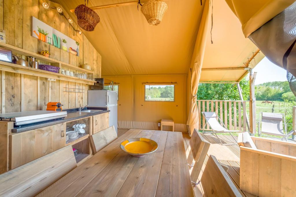 a kitchen with a wooden table in a tiny house at Gites Le Clos de Saires in Saires