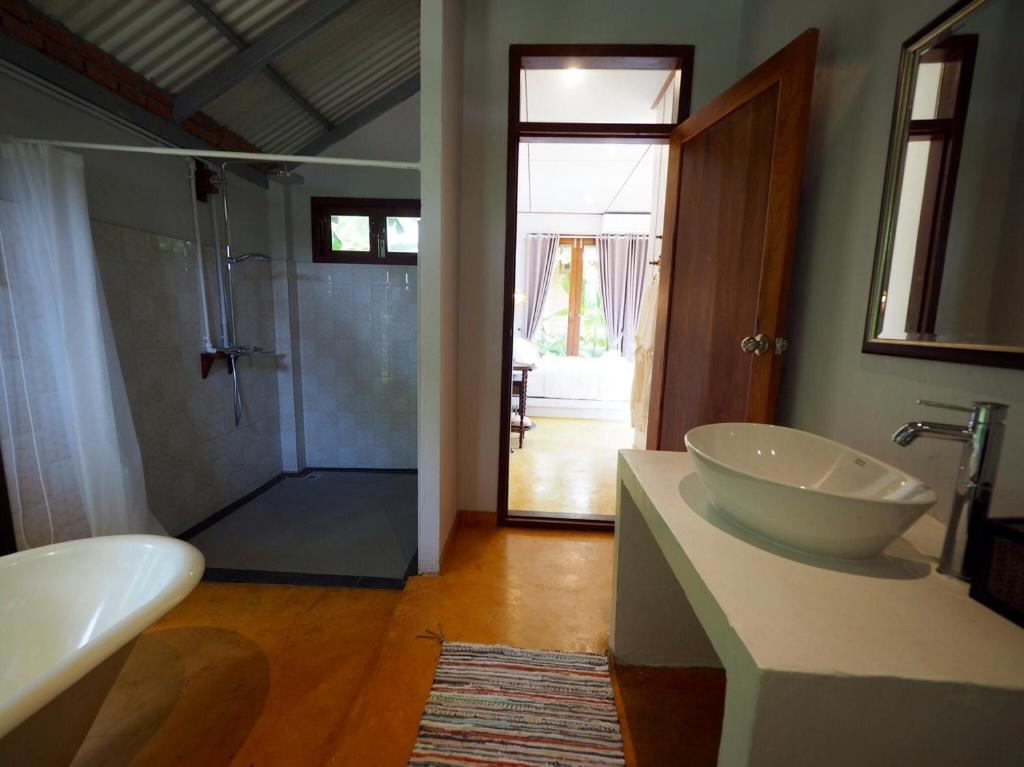 a bathroom with a tub and a sink and a shower at BaanSuk Sukhothai Resort in Sukhothai