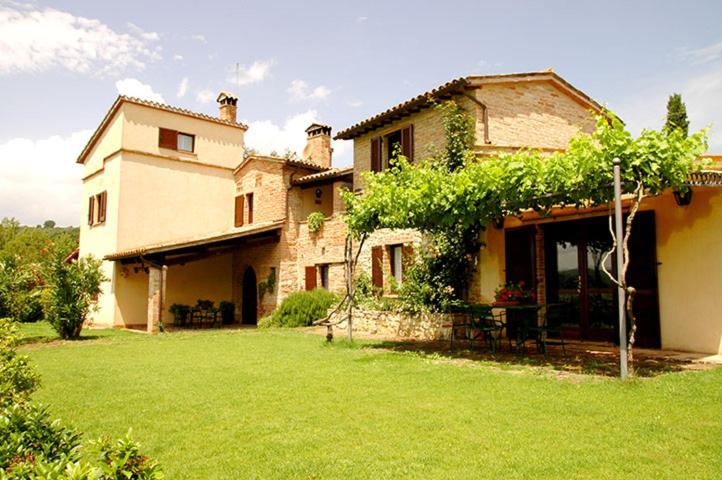 a large house with a green yard in front of it at Agriturismo La Mela in Collevalenza