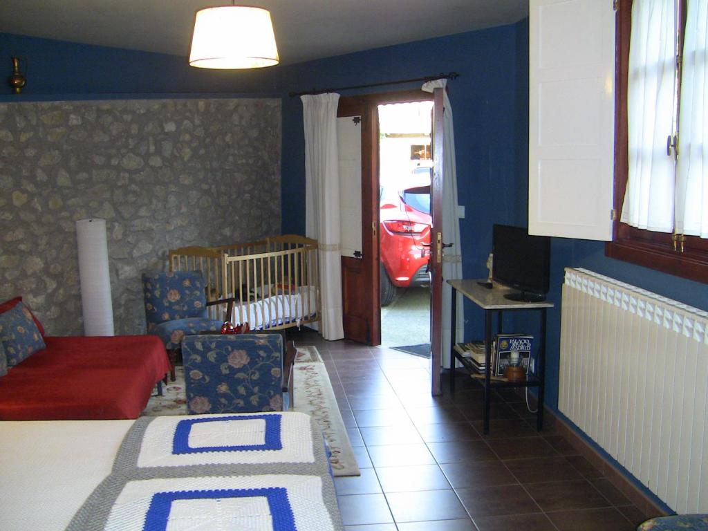 ein Wohnzimmer mit einem Bett und ein Zimmer mit einem Auto in der Unterkunft Casa Xan da Pena in Villarmayor
