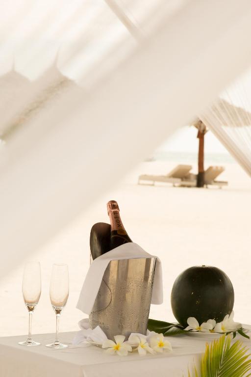 a table with a bottle of wine and two wine glasses at Gold Zanzibar Beach House & Spa in Kendwa
