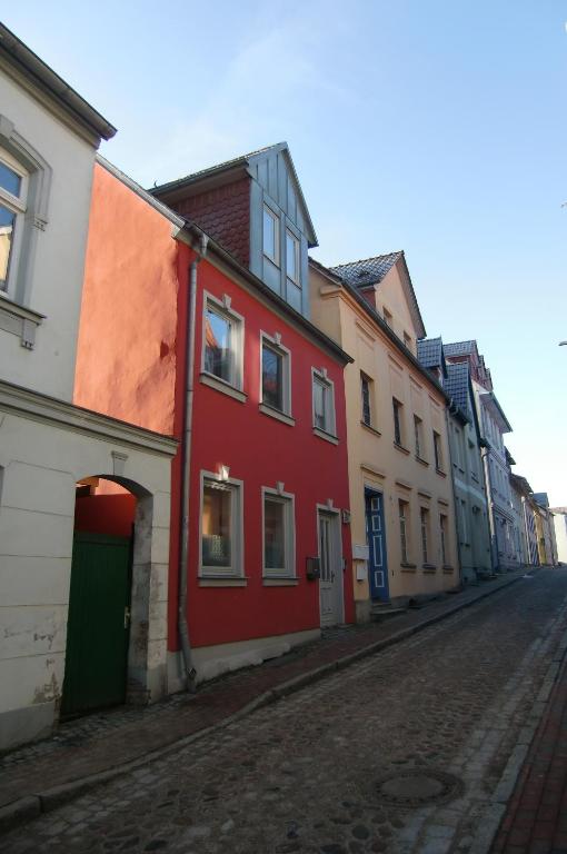 ein rotes Gebäude auf der Straßenseite in der Unterkunft Hafenkieker in Waren (Müritz)