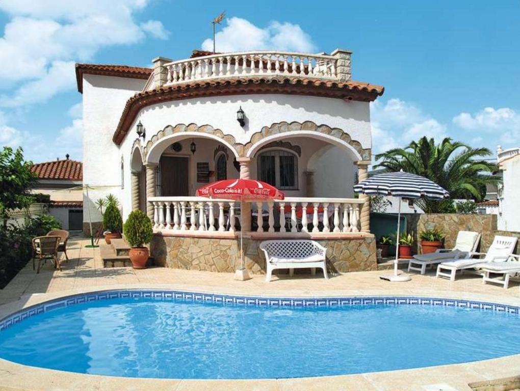 a villa with a swimming pool in front of a house at Casa Ricarda in Miami Platja