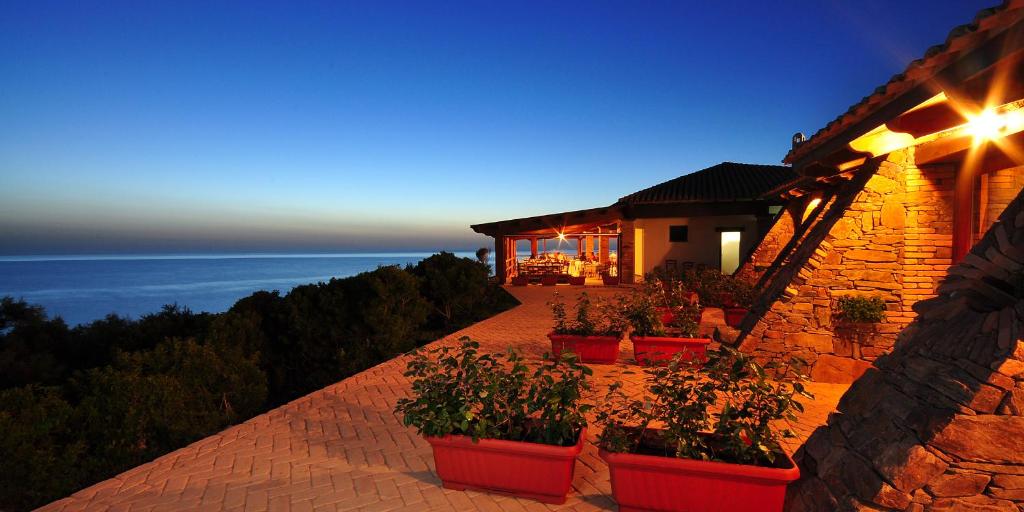 a house with potted plants on the side of it at Hotel Corsaro Nero in Portu Maga