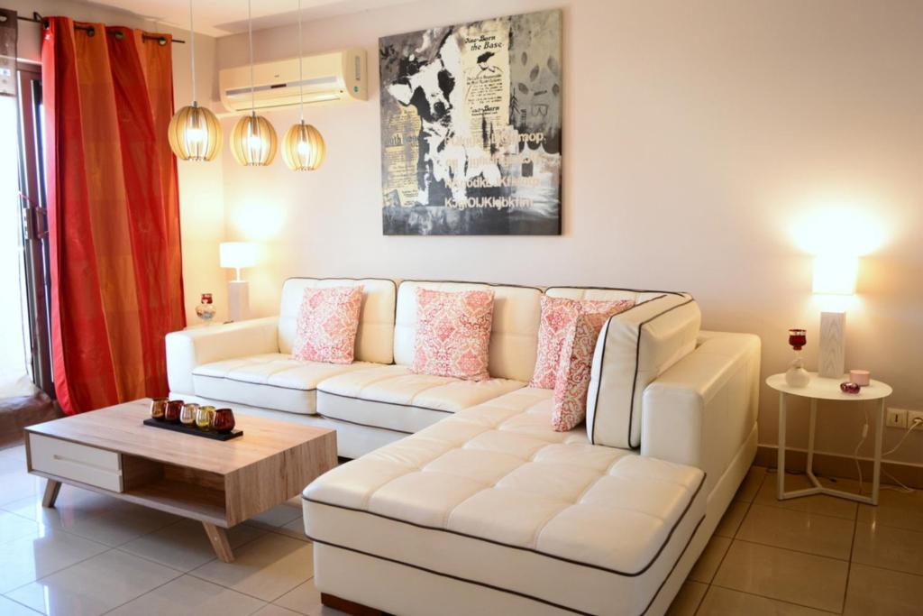 a living room with a white couch and a table at Hanalei duplex - downtown Papeete - 1 bedroom - AC - WiFi - 2 persons in Papeete