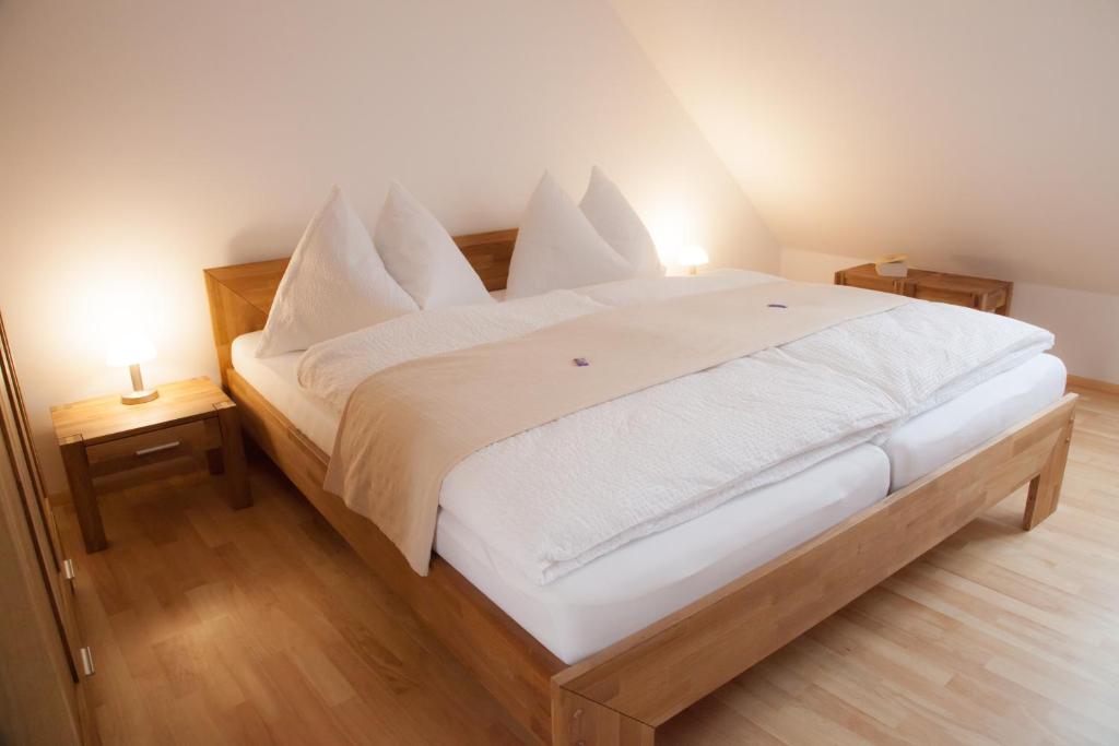 1 dormitorio con 1 cama grande con sábanas y almohadas blancas en Appartementhaus ECONTO, en Baden