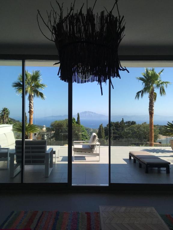 a room with a large window with palm trees at CASA DOS MARES in Tarifa