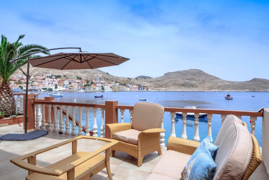 - Balcón con 2 sillas y sombrilla en Villa Skiadeni en Halki