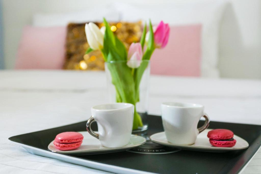 ein Tablett mit zwei Tassen und einer Vase Blumen in der Unterkunft Dream destination in Montévrain