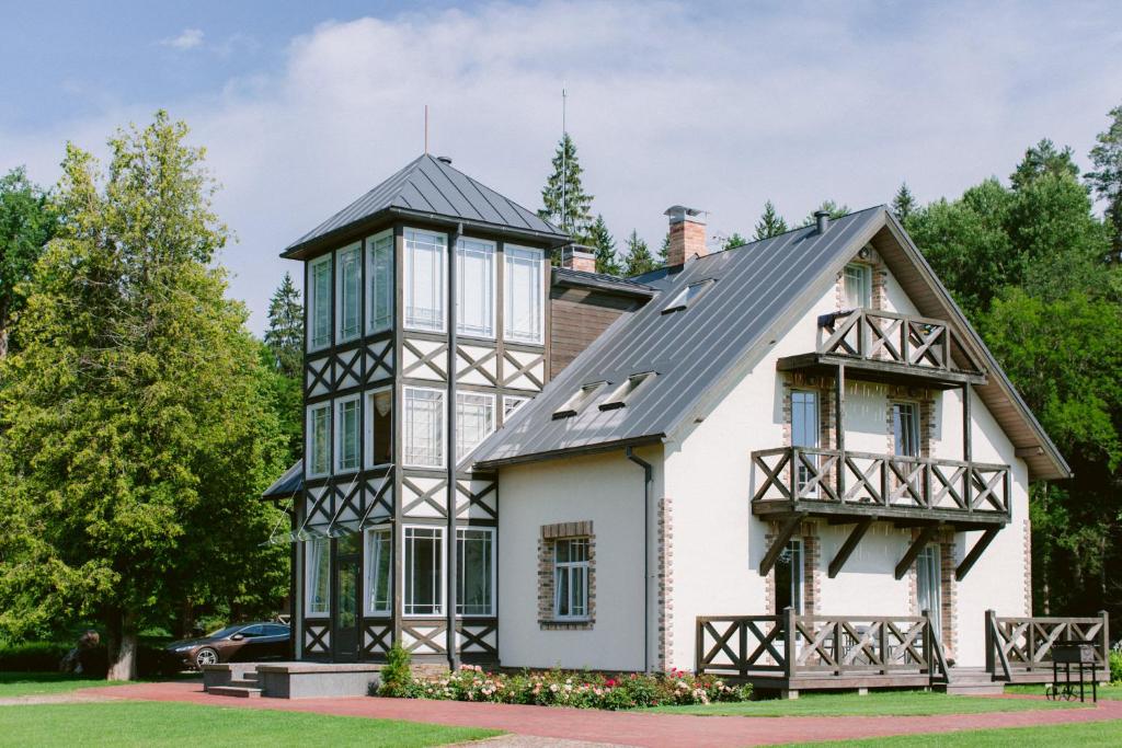 a house with a black and white turret at Boutique Hotel Bersas in Turaida