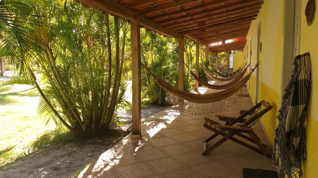 a porch with hammocks on the side of a house at Pousada Vida Mar in Barra Grande