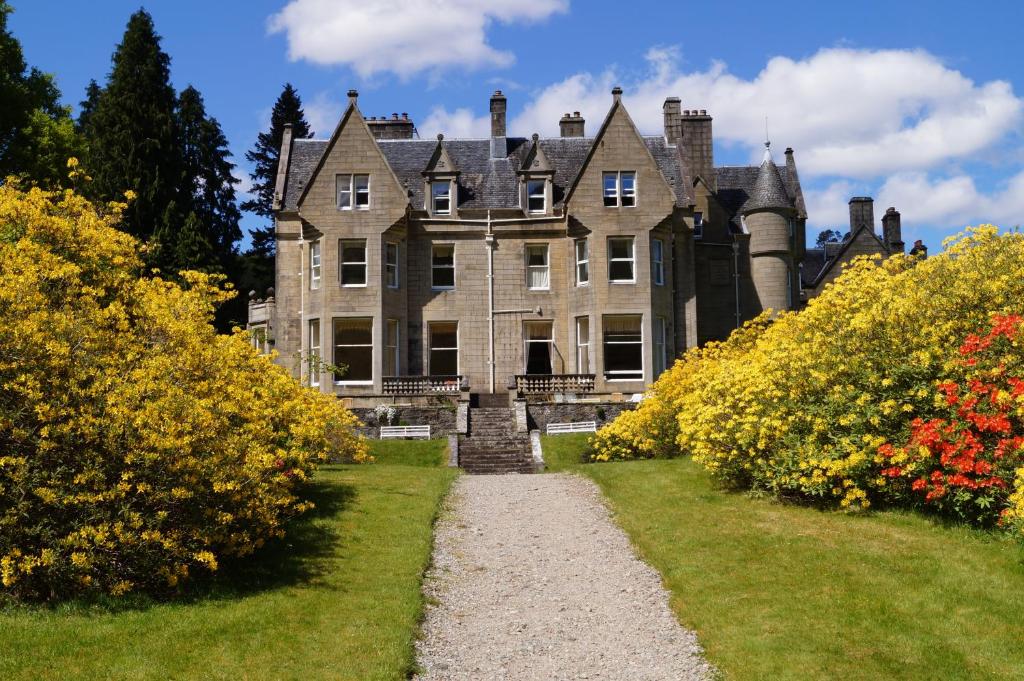 an old castle with a pathway in front of it at Glengarry Castle Hotel in Invergarry