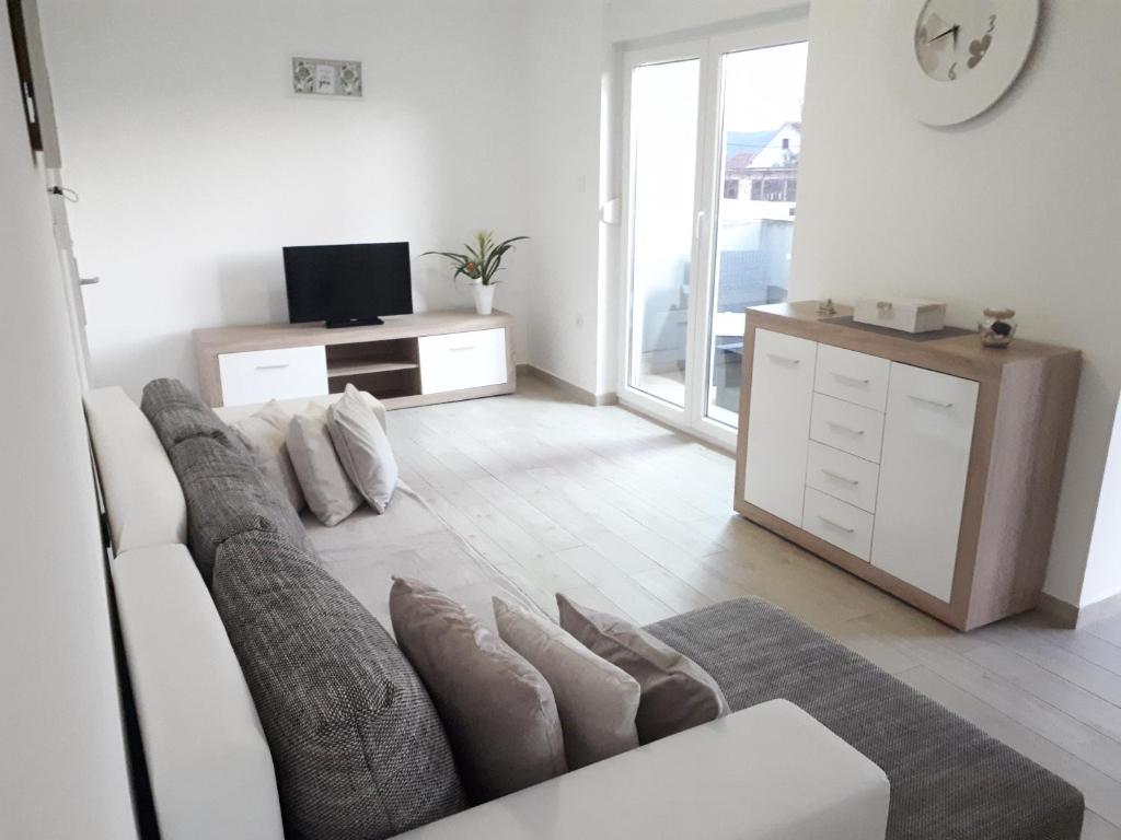 a living room with a couch and a tv at Spider Apartments in Pirovac