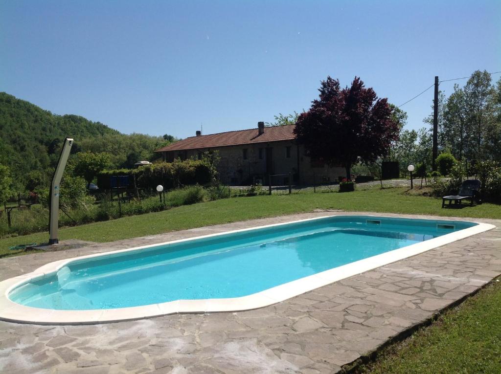 a swimming pool in a yard with a house at Agriturismo Il Picchio Verde in Licciana Nardi