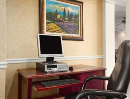 a computer sitting on a desk with a chair at Howard Johnson by Wyndham Jackson in Jackson