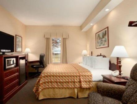 a hotel room with a bed and a television at Howard Johnson by Wyndham Jackson in Jackson