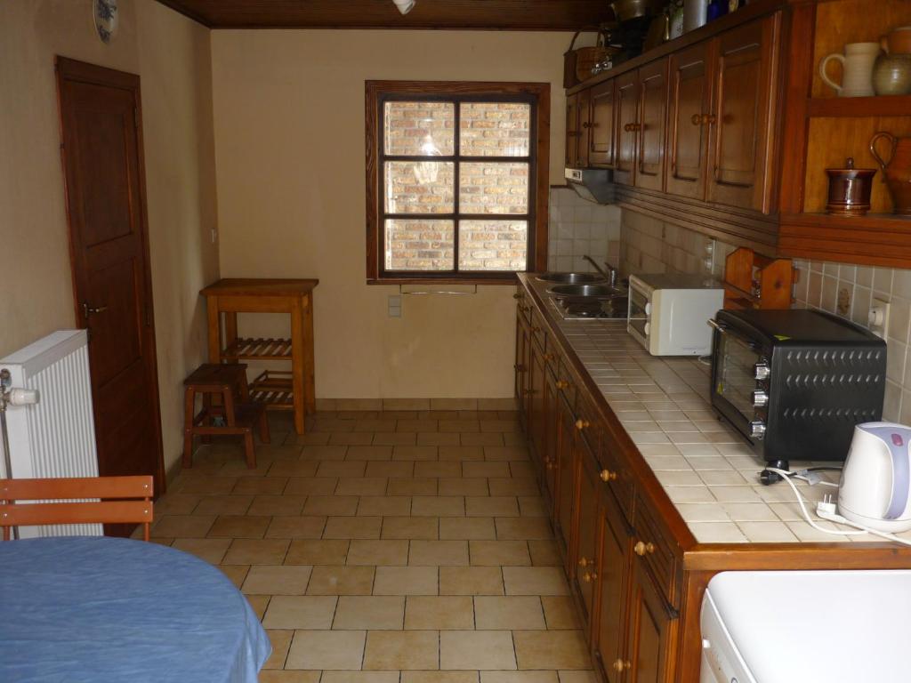 - une cuisine avec des placards en bois et un comptoir dans l'établissement Diane Chasseresse, à Soignies