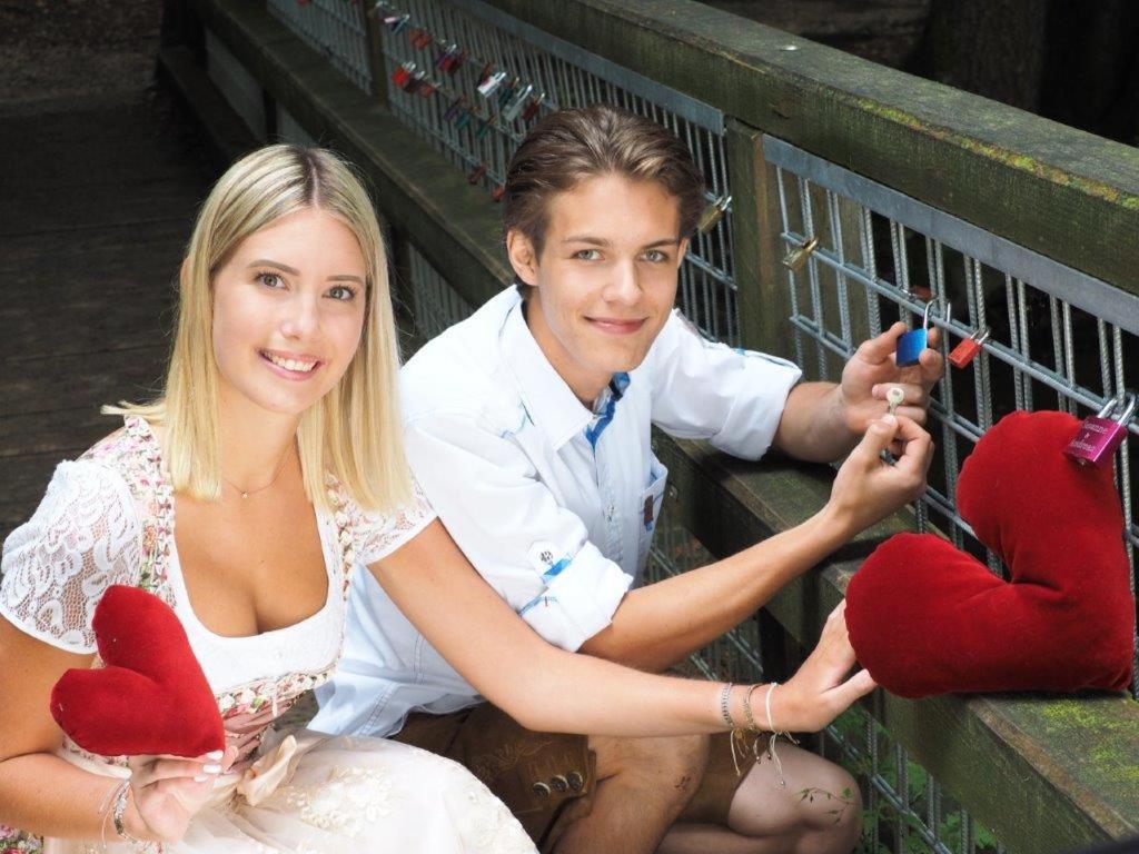 a man and a woman holding hearts on strings at Erlachmühle in Mondsee