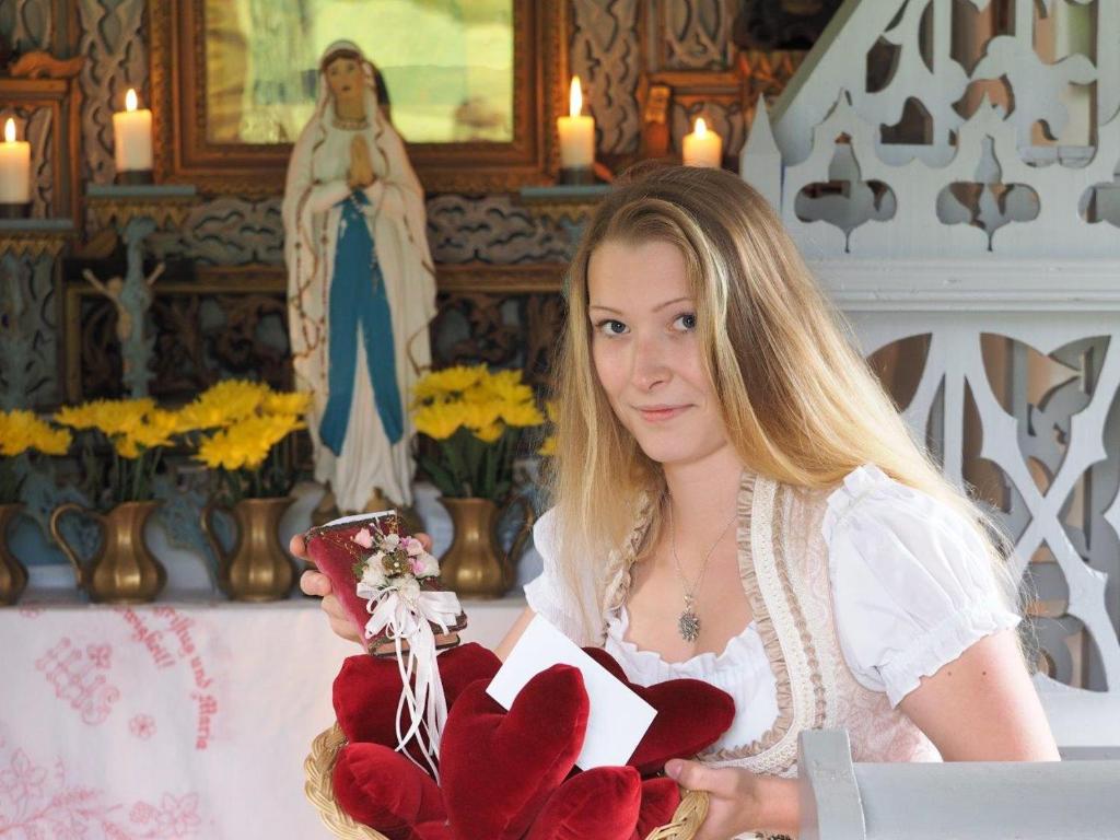 a woman holding a bouquet of red hearts at Erlachmühle in Mondsee