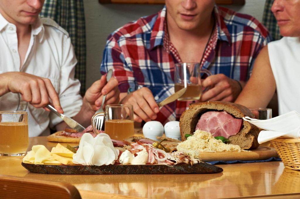 a group of people sitting at a table with a plate of food at Erlachmühle in Mondsee