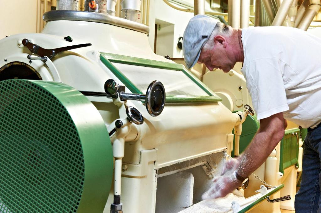 a man in a factory working on a machine at Erlachmühle in Mondsee