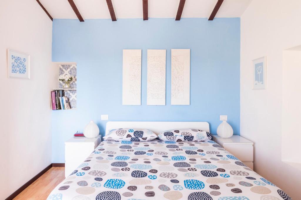 a bedroom with a bed with a blue wall at Florence Rooftop Apartments in Florence