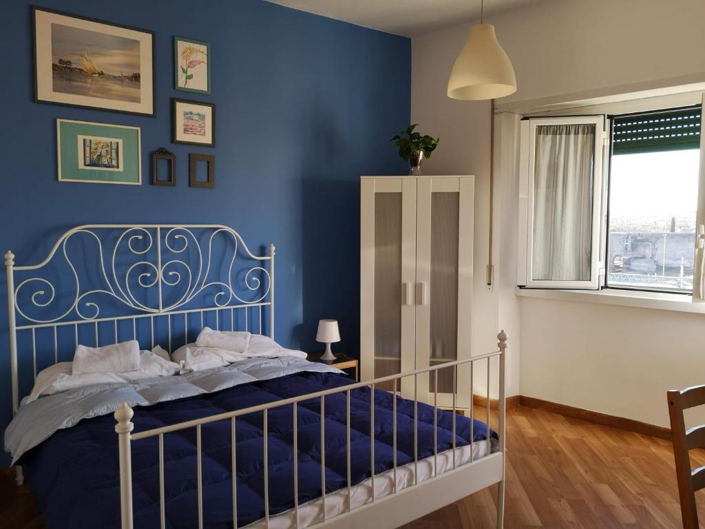ローマにあるPorta Maggiore GH Locazione Turisticaの青い壁のベッド付きの青いベッドルーム1室