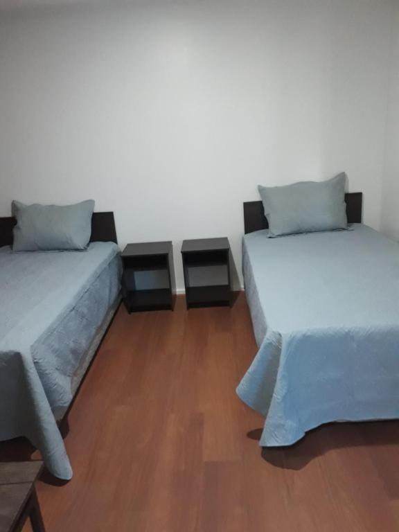 two beds sitting next to each other in a room at Hostal Alessandri in Curicó