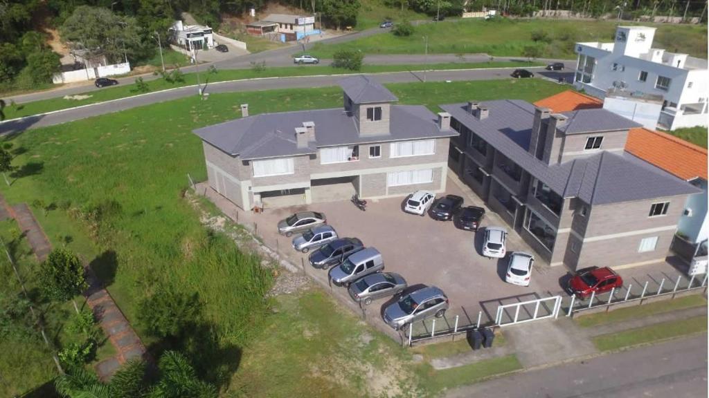an aerial view of a large house with parked cars at Residencial Infinito - Praia de Palmas in Governador Celso Ramos